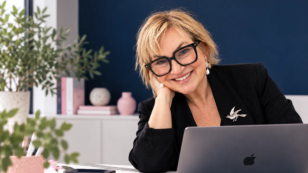 Jo McAuliffe, founder of GoClearcut, smiling at her desk with a laptop